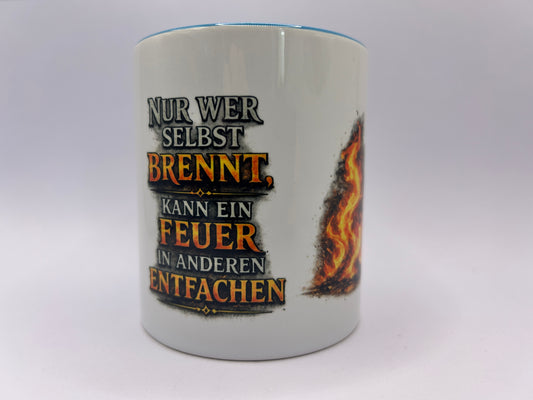 Weiße Keramiktasse mit dem Spruch „Nur wer selbst brennt, kann ein Feuer in anderen entfachen“ und dekorativem Flammenmotiv. Motivations-Tasse für Büro und Alltag.
