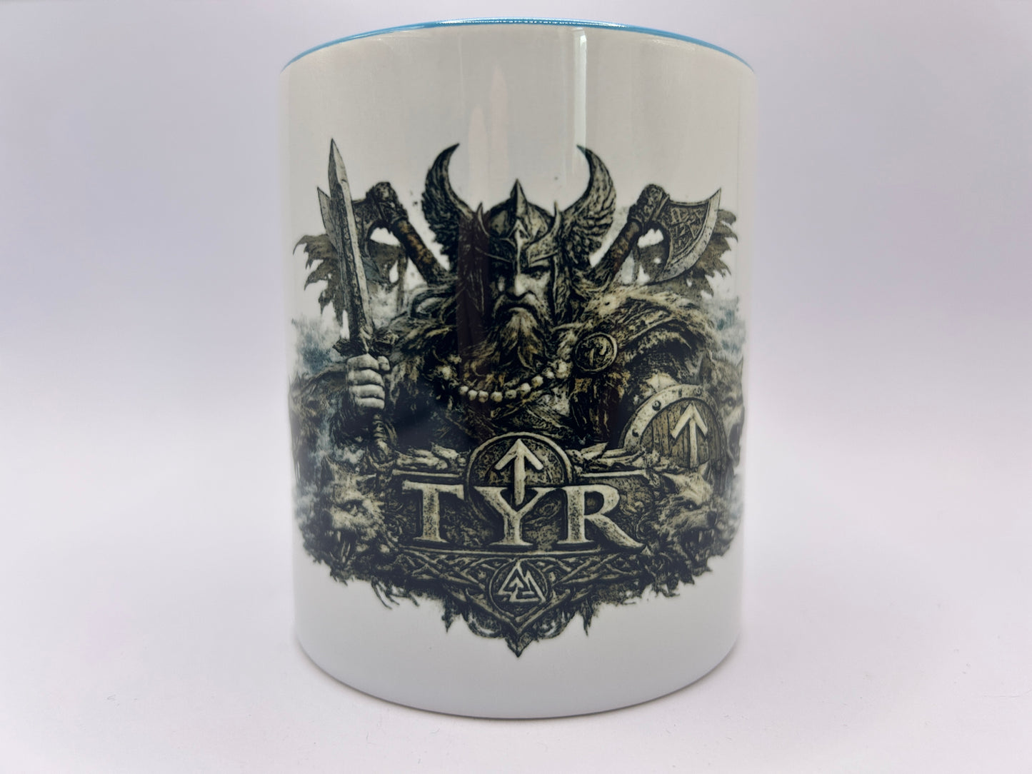 Weiße Keramiktasse mit Tyr Motiv aus der nordischen Mythologie. Detailreiche Darstellung des nordischen Kriegsgottes mit Schwert, Schild und Wikinger-Rüstung.
