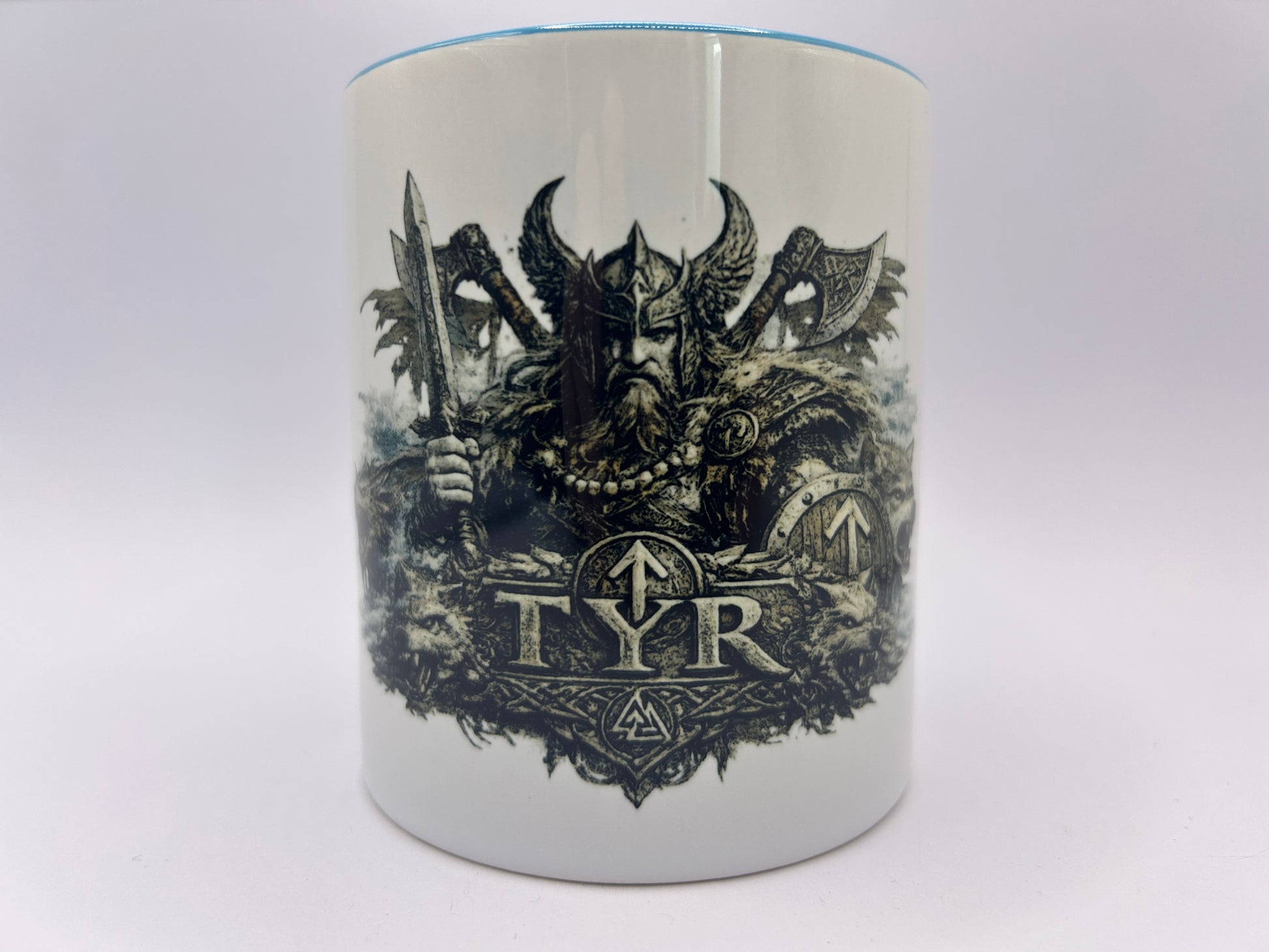 Weiße Keramiktasse mit Tyr Motiv aus der nordischen Mythologie. Detailreiche Darstellung des nordischen Kriegsgottes mit Schwert, Schild und Wikinger-Rüstung.