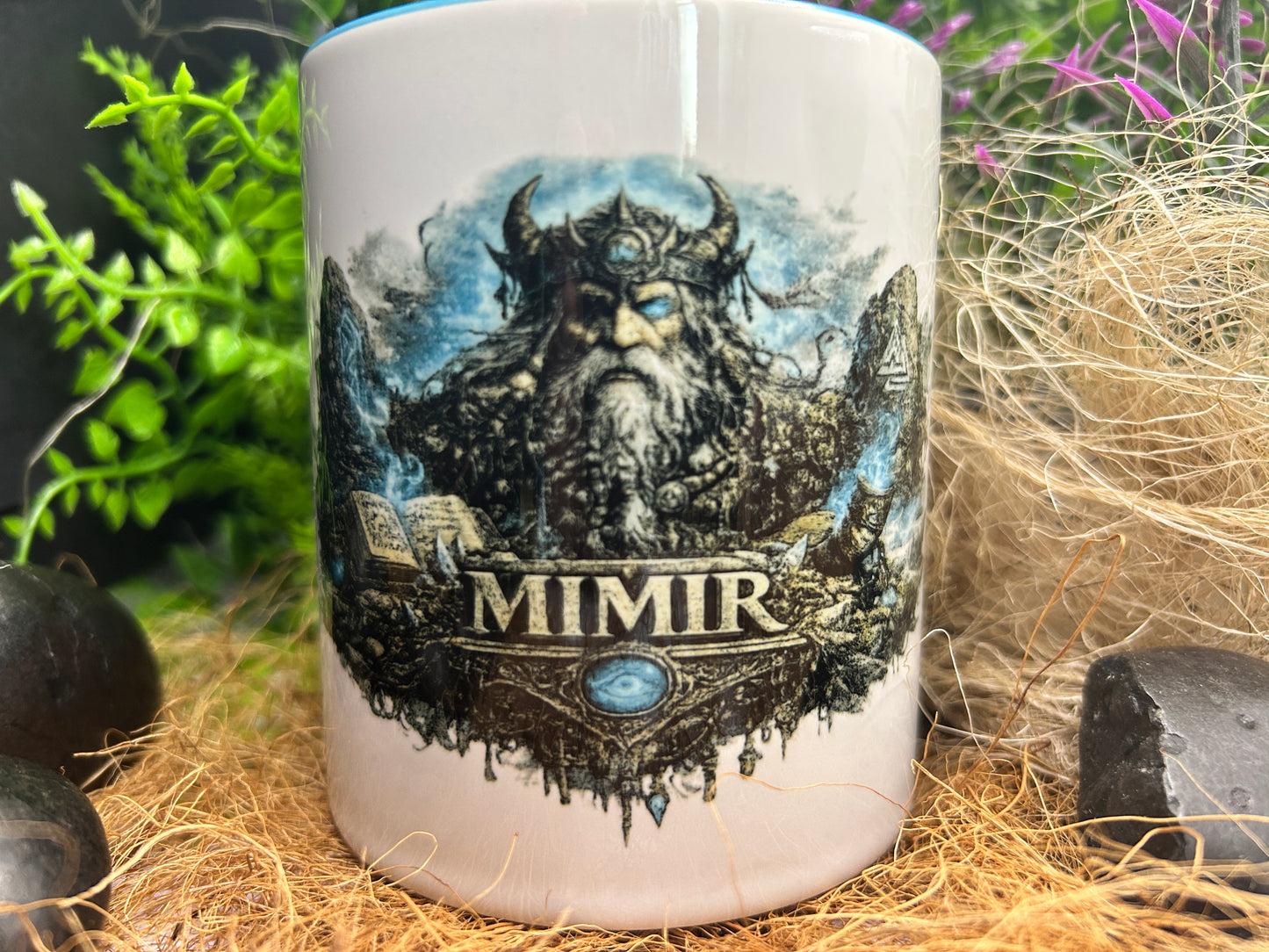 Wikinger Tasse mit Mimir Motiv dekorativ zwischen Naturmaterialien präsentiert. Ideales Geschenk für Fans nordischer Mythologie und Wikingerkultur.
