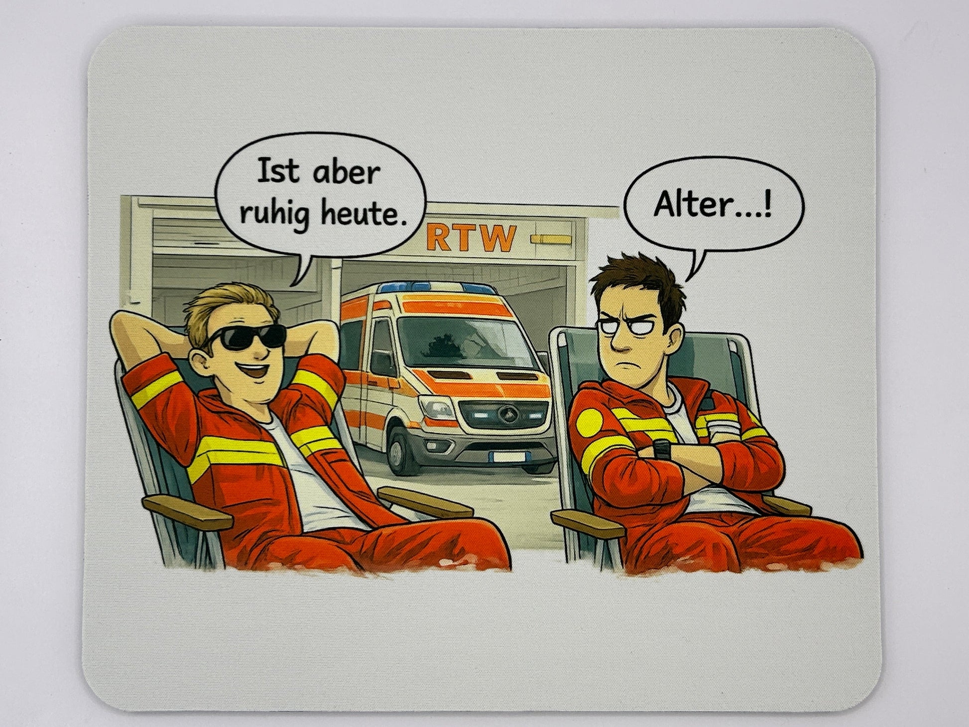RTW Mauspad mit zwei Rettungsdienstmitarbeitern vor einem Rettungswagen und dem Spruch „Ist aber ruhig heute. Alter…!“.