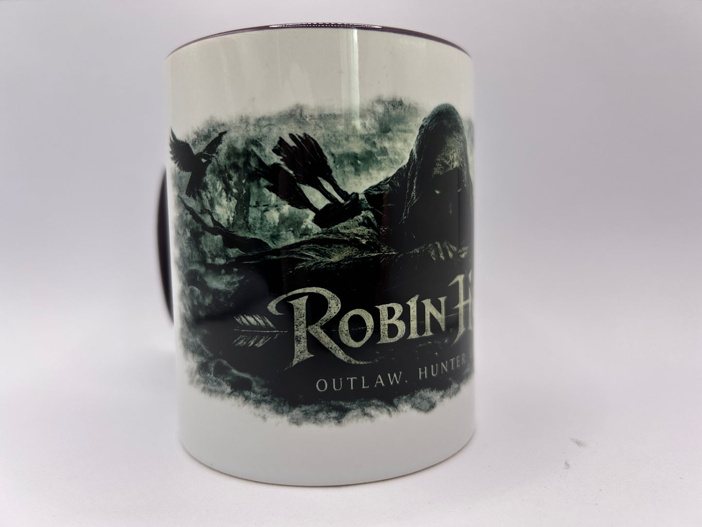 Detailansicht der Robin Hood Keramiktasse mit Raben, Pfeilen und dunklem Sherwood-Forest-Fantasy-Design.