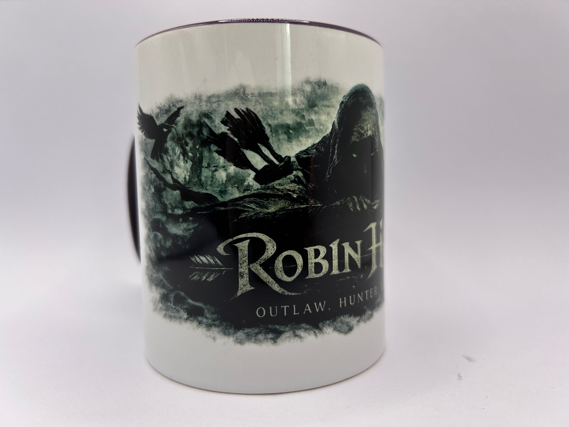 Detailansicht der Robin Hood Keramiktasse mit Raben, Pfeilen und dunklem Sherwood-Forest-Fantasy-Design.