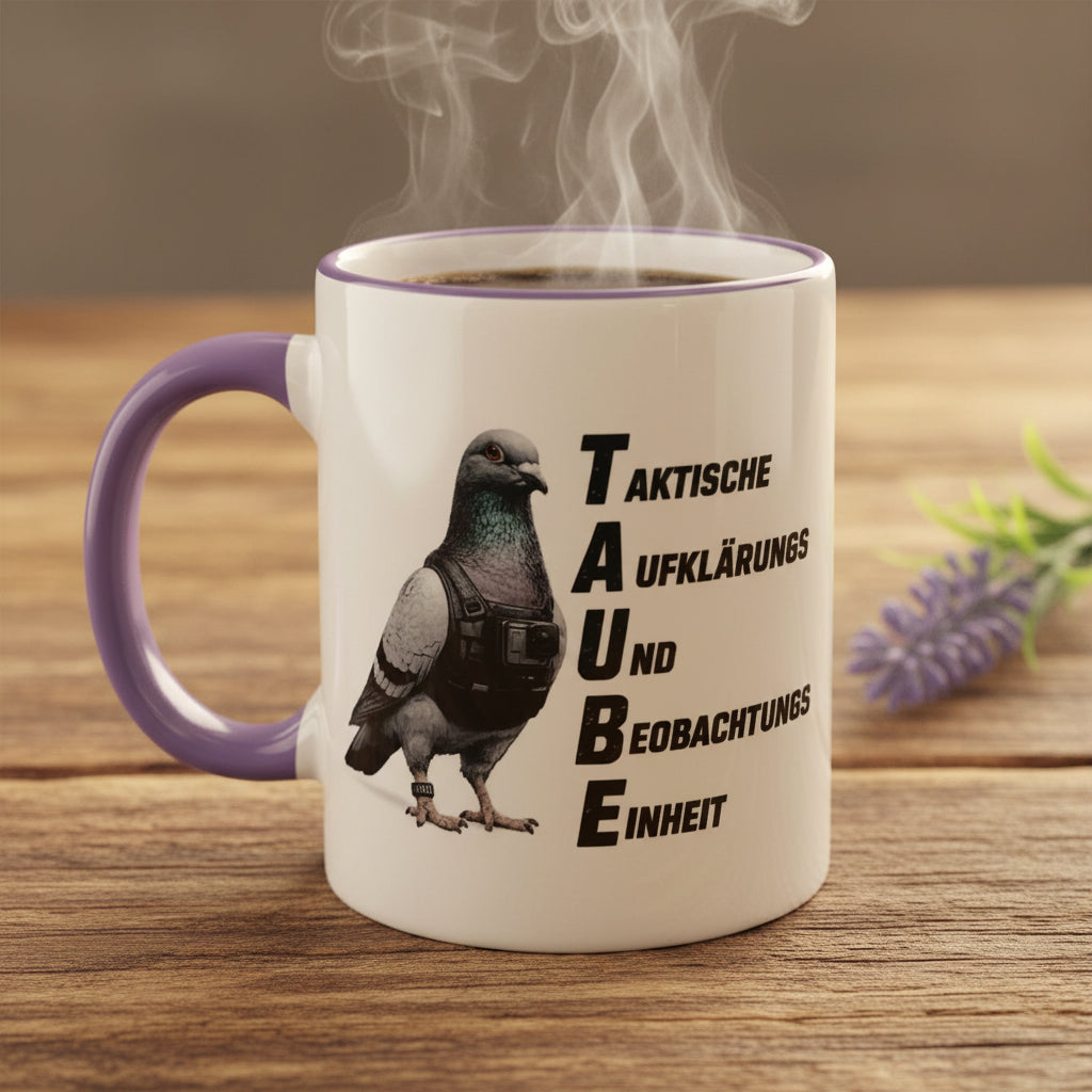 Weiße Kaffeetasse mit TAUBE-Motiv auf einem Tisch zwischen dekorativen Steinen und Lavendel. Das Design zeigt eine Taube mit taktischer Weste und den Schriftzug „Taktische Aufklärungs- und Beobachtungseinheit“.